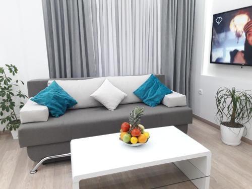 a living room with a couch and a table with a bowl of fruit at Abbazia Apartments Free Parking Near Center and Vrbas River in Banja Luka