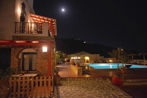 a house with a swimming pool at night at Paradisia Villas in Naxos Chora