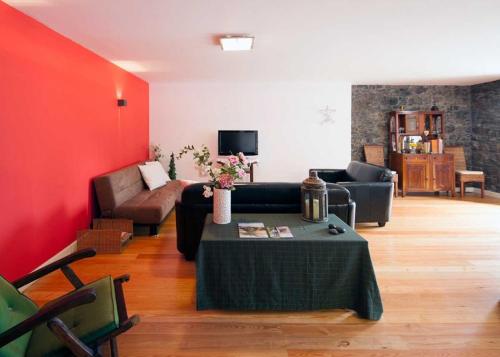 a living room with a couch and a table at Casa do João da Eira in Seixal