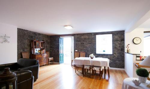 a living room with a dining room table and a kitchen at Casa do João da Eira in Seixal