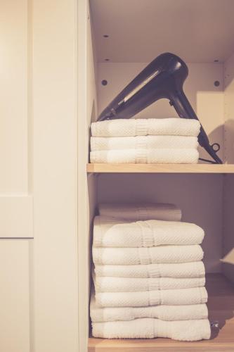 a stack of towels on a shelf in a bathroom at Landhuisjes Bij De Wouterbron in Oudsbergen 