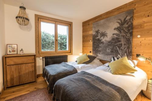deux lits dans une chambre aux murs en bois dans l'établissement Appartement Native, à Chamonix-Mont-Blanc