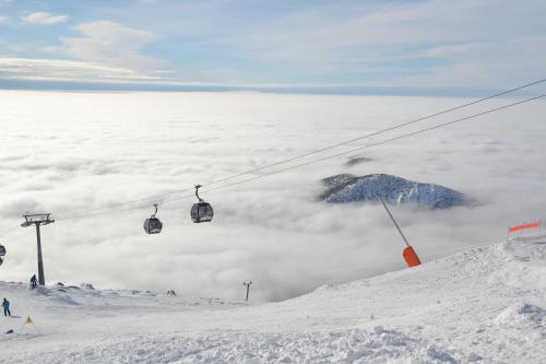 a ski lift above a pile of snow and clouds at Nina Liptov in Liptovský Ján