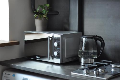 a microwave sitting on top of a kitchen counter at Apartment Desyatinnaya in Velikiy Novgorod