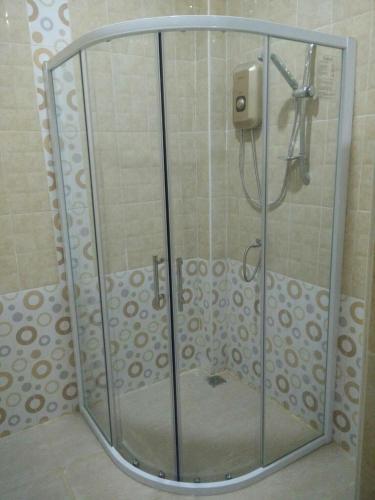 a shower with a glass door in a bathroom at Ban Thung Talay Mok Chiangdao in Chiang Dao
