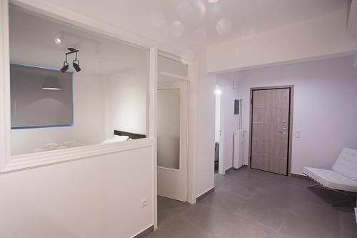 a white room with a hallway with a bench and a door at Dimokritou 4 Apartment in Athens