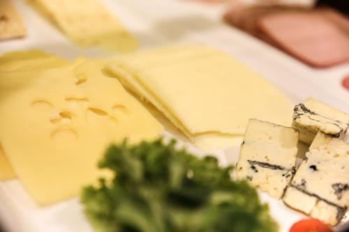 a plate of cheese and broccoli on a table at Hotel Friedenseiche in Benediktbeuern