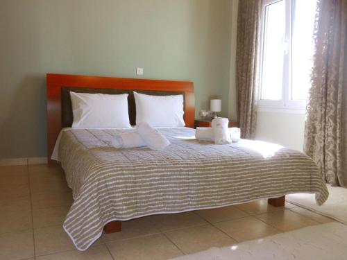 una camera da letto con un grande letto con cuscini e una finestra di Thalia's Stone house a Ipsilándis