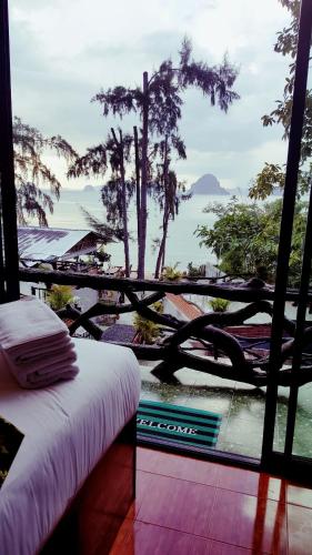 a room with a bed and a view of the ocean at Baan Tubkaek Hotel in Tab Kaek Beach