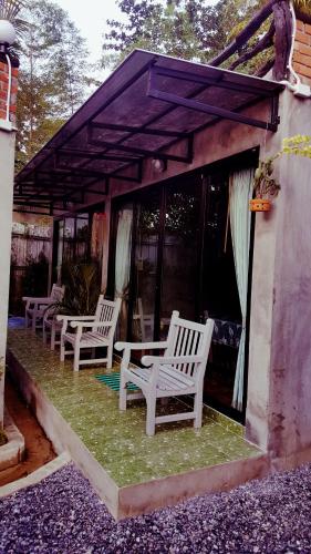 a group of white chairs sitting on a patio at Baan Tubkaek Hotel in Tab Kaek Beach