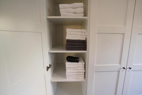 a bathroom with white towels in a closet at Landhuisjes Bij De Wouterbron in Oudsbergen 