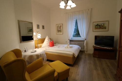 Una habitación de hotel con dos camas y un televisor. en Villa Amber, en Bad Kissingen