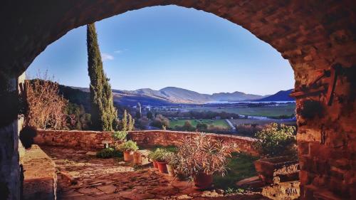 a view through an arch of a stone wall with potted plants at BanastónEra in Usana