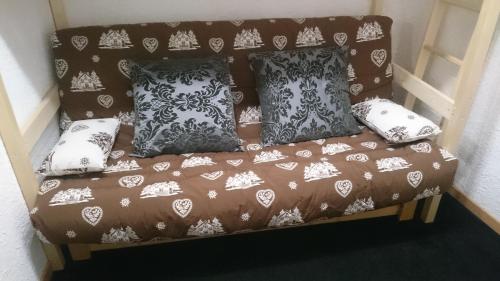 a couch with pillows on it in a room at Le Montana in Les Deux Alpes