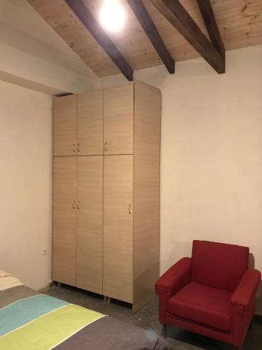 a bedroom with a red chair and a closet at Taygetos in Sparti