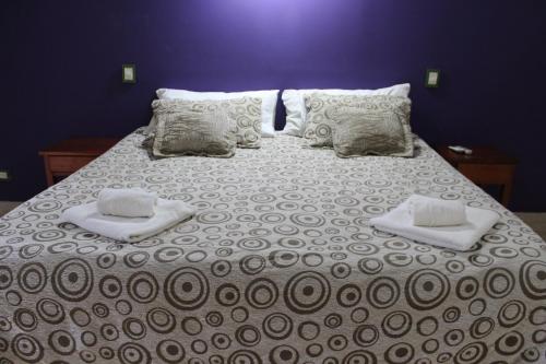 a large bed with two towels and pillows on it at Palo Rosa Lodge in Puerto Iguazú