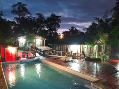 a swimming pool in front of a house at night at Palo Rosa Lodge in Puerto Iguazú
