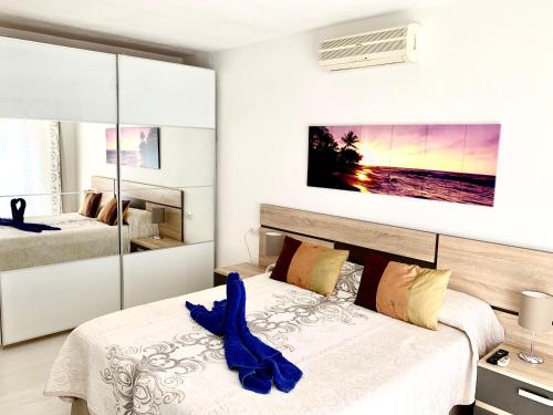 ein Schlafzimmer mit zwei Betten mit blauen Schuhen darauf in der Unterkunft Los Cristianos Best Beach View in Arona
