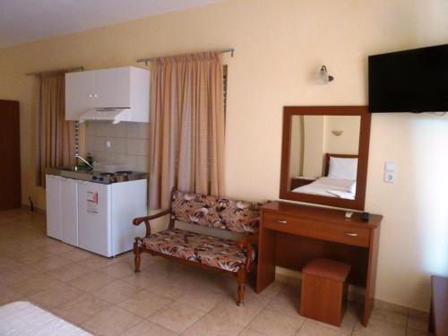 Pokój z lustrem, krzesłem i biurkiem w obiekcie Elafonisos Diamond Resort w Elafónisos