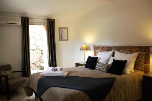 un dormitorio con una cama grande y una ventana en Concadoro, en Porto Vecchio