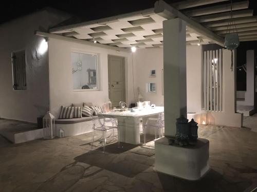 Cette chambre blanche dispose d'une table et d'un canapé. dans l'établissement Villa Casa Dodo Mare, à Plage d'Élia