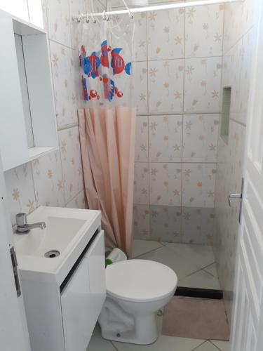 y baño con aseo y lavamanos. en Suítes a Beira Mar, en Rio das Ostras