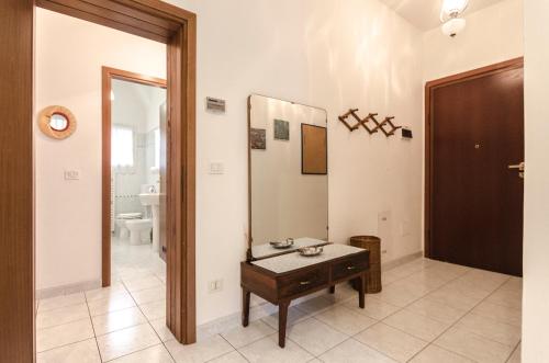 ein Bad mit einem Tisch und einem Spiegel in der Unterkunft Romagnoli apartment in Bologna