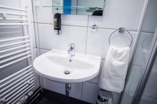 a bathroom with a white sink and a mirror at Hotel Leo in Eggenstein-Leopoldshafen