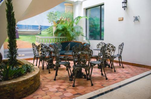 a patio with a table and chairs and a fountain at Hotel Castilla Real in Pereira