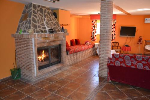 a living room with a fireplace and a red couch at Flor de la Jara in Cobisa
