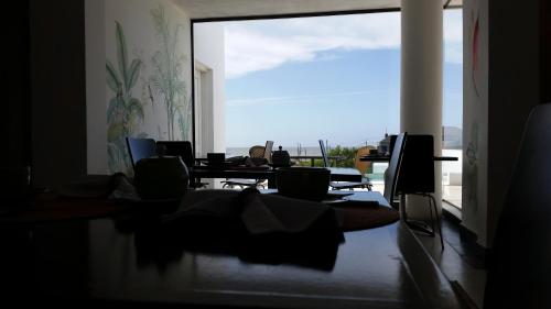 a room with tables and chairs and a large window at Posada de los Pajaros in Punta del Este