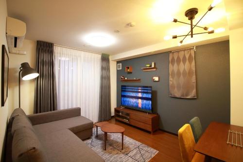 a living room with a couch and a flat screen tv at W&M House in Kanazawa