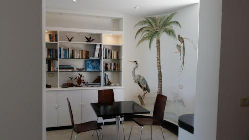 uma sala de jantar com uma mesa e uma palmeira em Posada de los Pajaros em Punta del Este