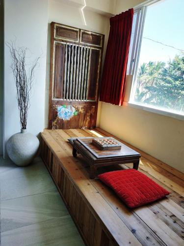 a room with a bench with a table in front of a window at Cenacle B & B in Chenggong