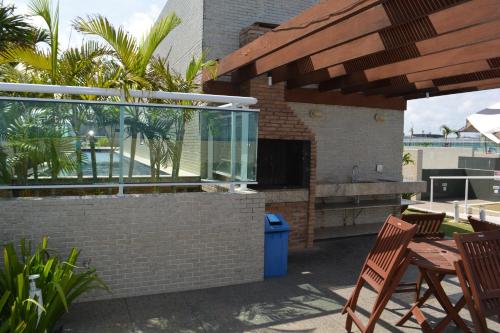 a patio with a table and chairs and a building at Sun Paradise - JTR in Maceió