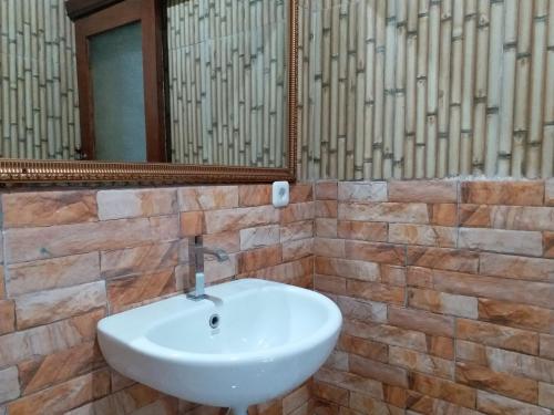 y baño con lavabo blanco y espejo. en Kembar Inn Padangbai, en Padangbai