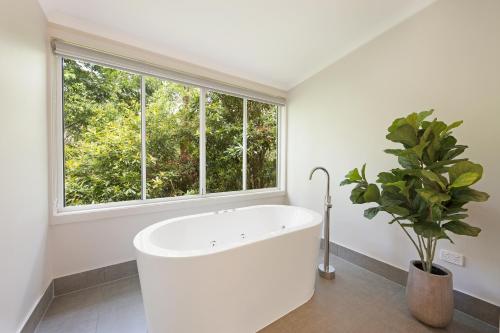 een badkamer met een wit bad en een raam bij Clouds Montville in Montville