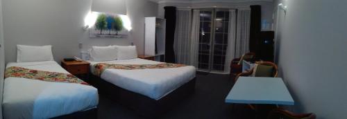 a hotel room with two beds and a window at Colonial Lodge Motel in Taupo