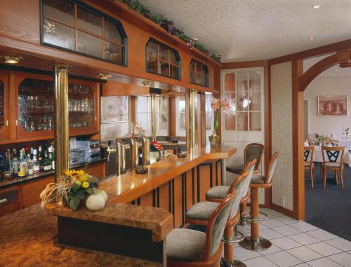 a bar with chairs and a counter in a room at Hotel Schatulle in Laufersweiler