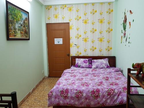 a bedroom with a bed with a pink comforter at Hanu's House in Hanoi