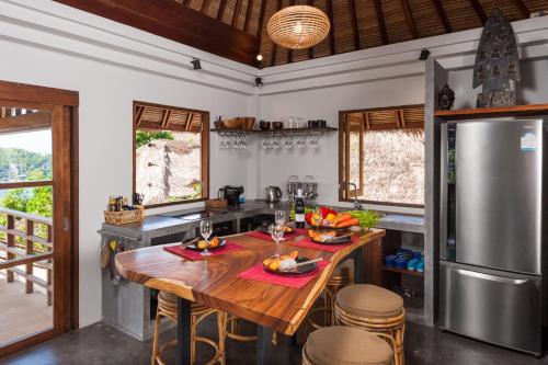 a kitchen with a wooden table and a refrigerator at The Fisherman's Villas in Koh Tao