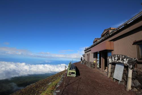 a building on a hill with a view of the ocean at Goraikou Sansou Mt Fuji New 7th Station Fujinomiya Route in Fujinomiya