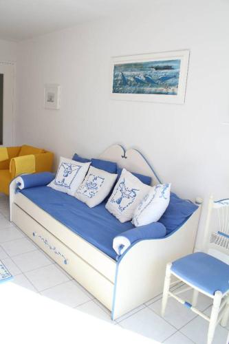 Cette chambre comprend un lit avec des oreillers et une chaise. dans l'établissement La Marinière, à Mesquer