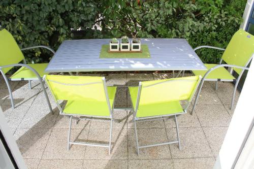 une table et des chaises avec une table bleue et des chaises jaunes dans l'établissement La Marinière, à Mesquer
