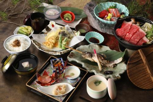 a table topped with different types of food on plates at Karuizawakurabu Hotel 1130 Hewitt Resort in Tsumagoi