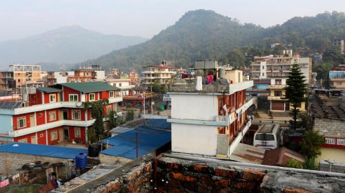 a city with buildings and mountains in the background at Harry Guest House & Restaurant in Pokhara