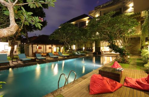 a swimming pool with chairs and a hotel at Argya Santi Resort in Jimbaran