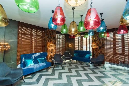 a lobby with blue couches and colorful chandeliers at East Astana Hotel in Astana