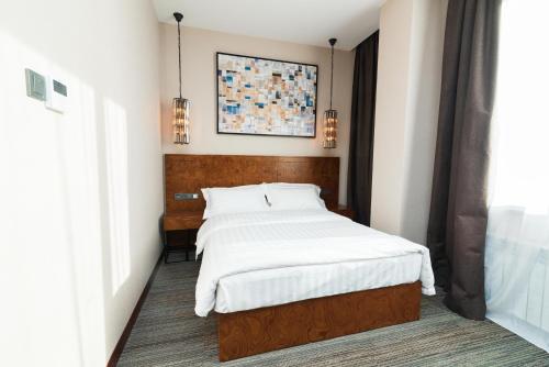 a bedroom with a bed and a painting on the wall at East Astana Hotel in Astana