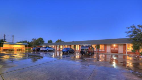 a building with cars parked in a parking lot at Moama Central Motel in Echuca